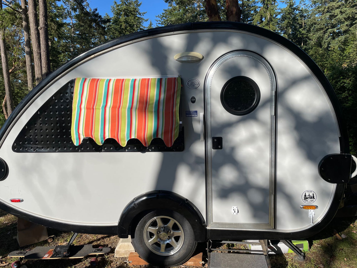 and diamond-pattern stainless backsplash.|RV rental: Compact interior with a multi-cushion bed