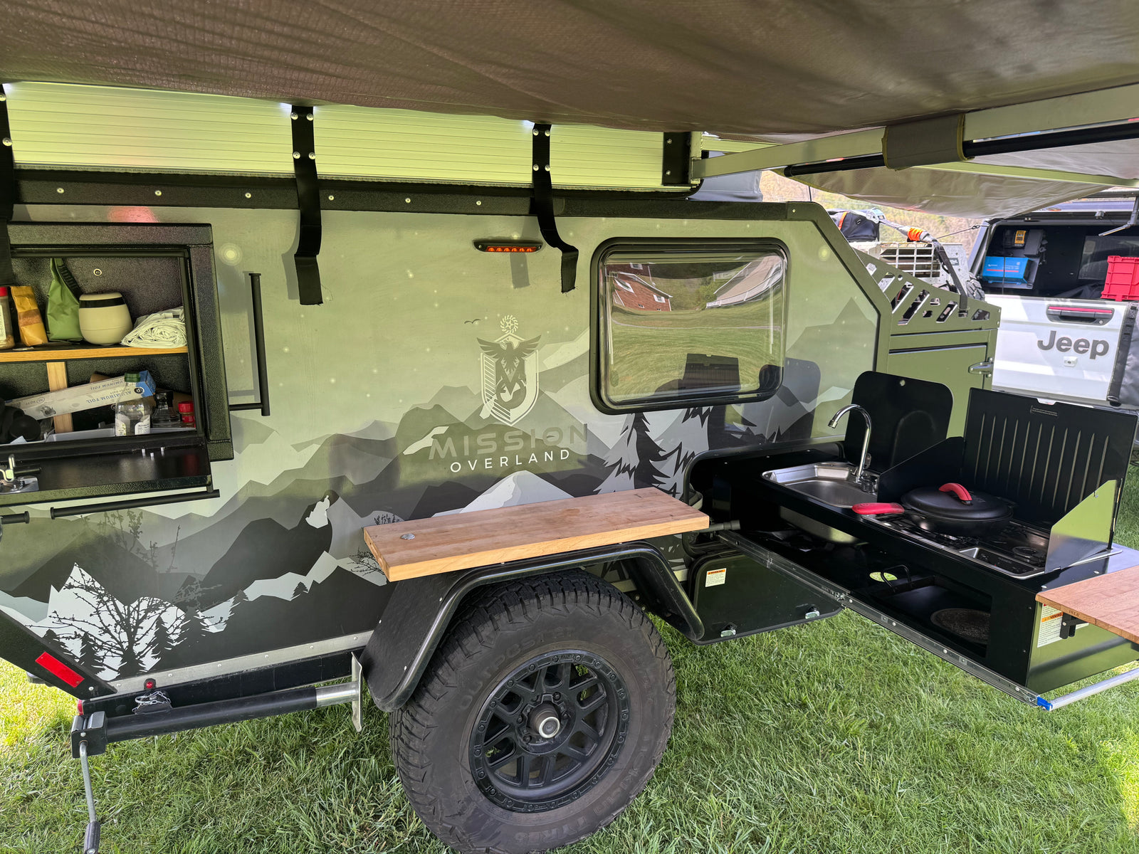 Mission Overland trailer's outdoor kitchen. Sink, stove, and counter space for camping or an RV rental. Ready for adventure!