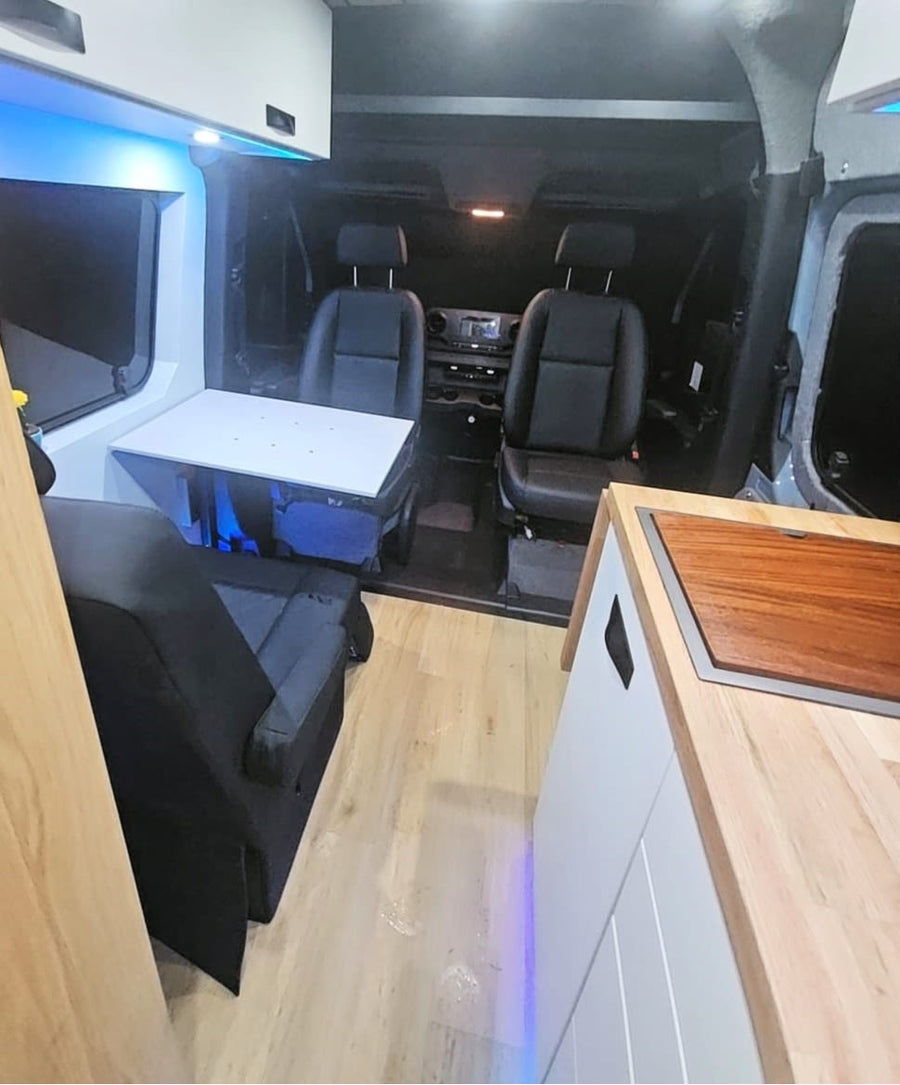 parked on grass.|Cozy RV rental interior: white bed