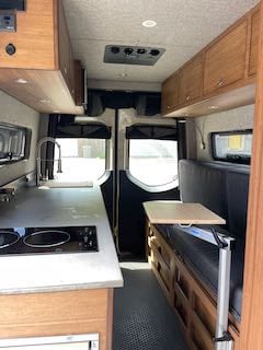 and integrated storage.|Explore this modern RV rental kitchen featuring a sink