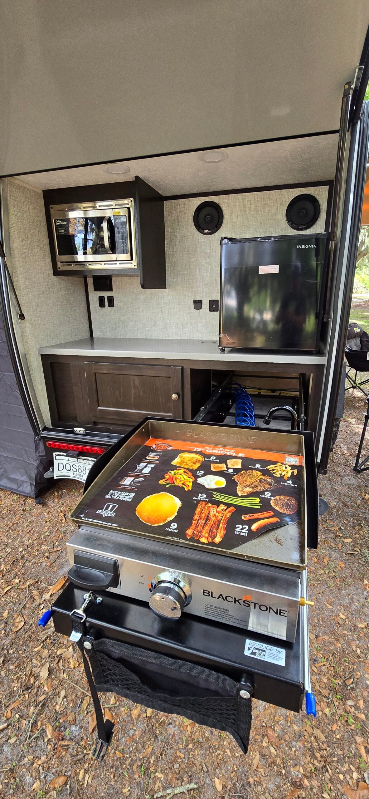 This RV rental features a convenient outdoor kitchen with a microwave, mini-fridge, and pull-out Blackstone griddle for camp cooking.