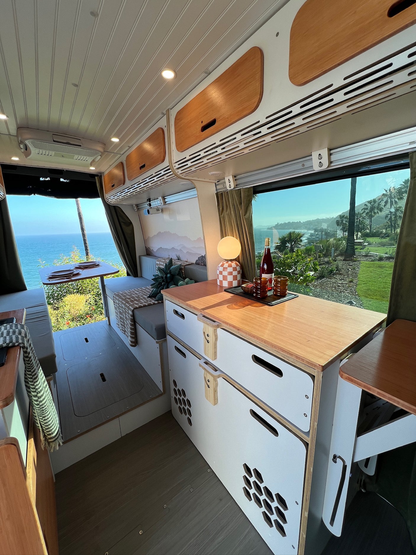 Stunning rv rental interior with expansive ocean views. Features dining, lounge, and kitchen space, perfect for adventure.
