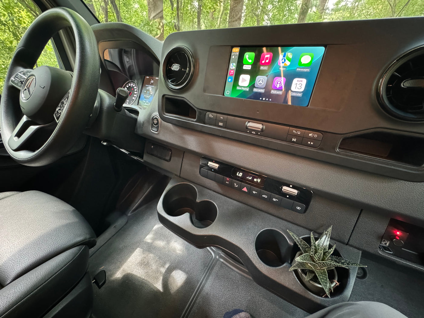 Mercedes-Benz RV rental interior: Modern dashboard with Apple CarPlay screen, climate controls, and cup holders.