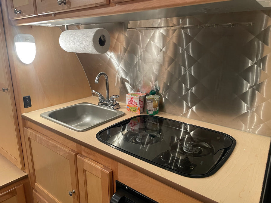 with tow vehicle visible.|Inside an RV rental: a compact dinette with patterned cushions