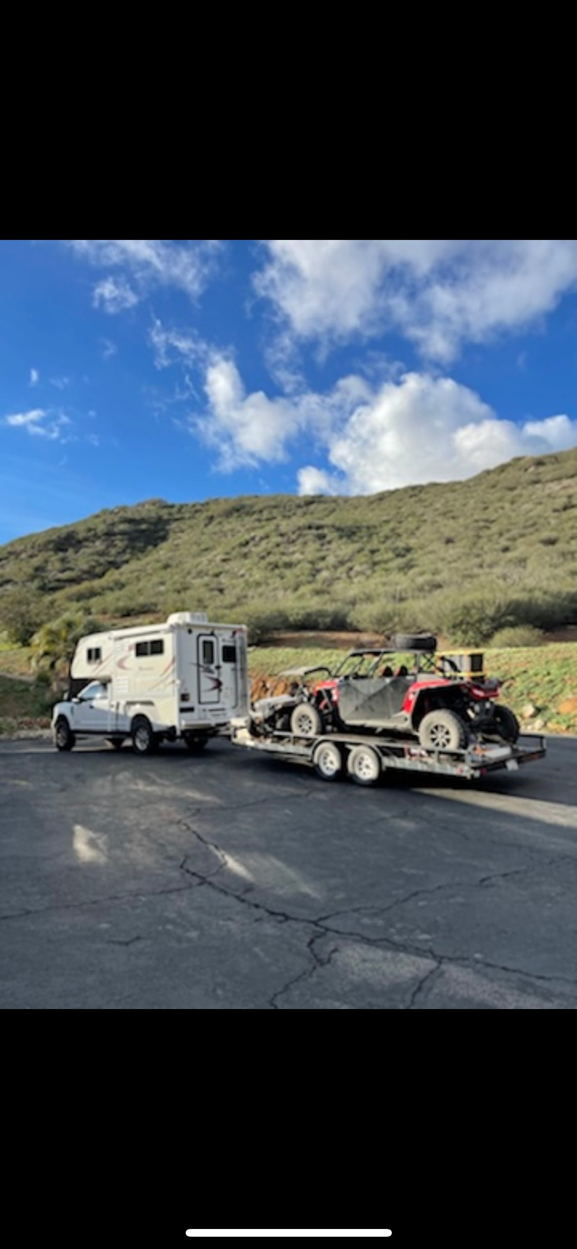 Adventure awaits! An rv rental truck camper towing two off-road UTVs in a scenic outdoor setting. — photo 15