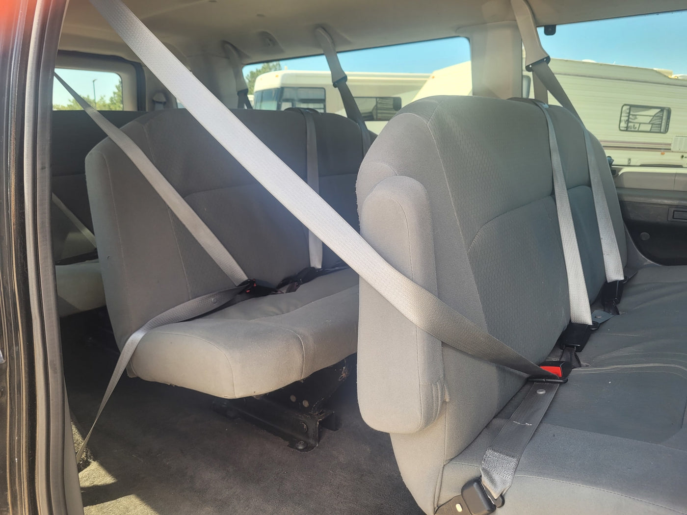 ready for adventure.|Interior of a passenger van showing multiple rows of seats. RVs are seen outside — photo 5