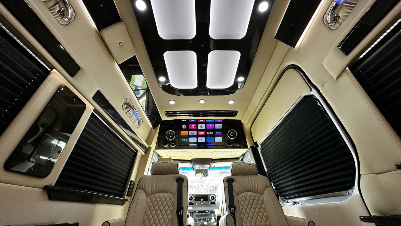 Luxurious RV rental interior featuring plush seating, a large entertainment system with streaming apps, and stylish lighting.