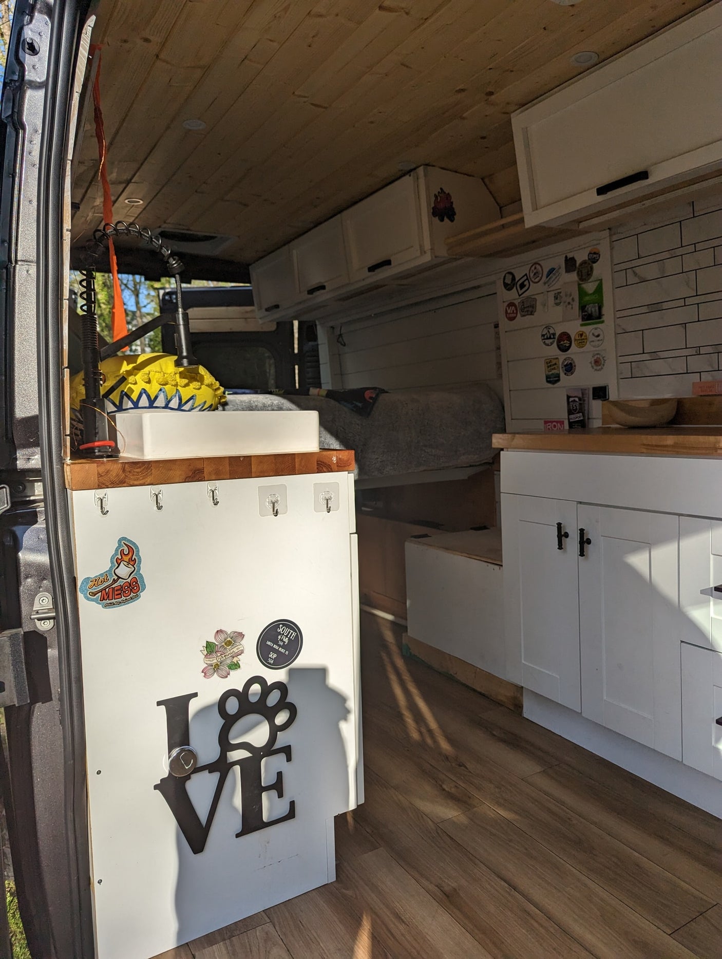 and smart overhead storage with wicker baskets.|This RV rental camper van interior features a well-equipped kitchen