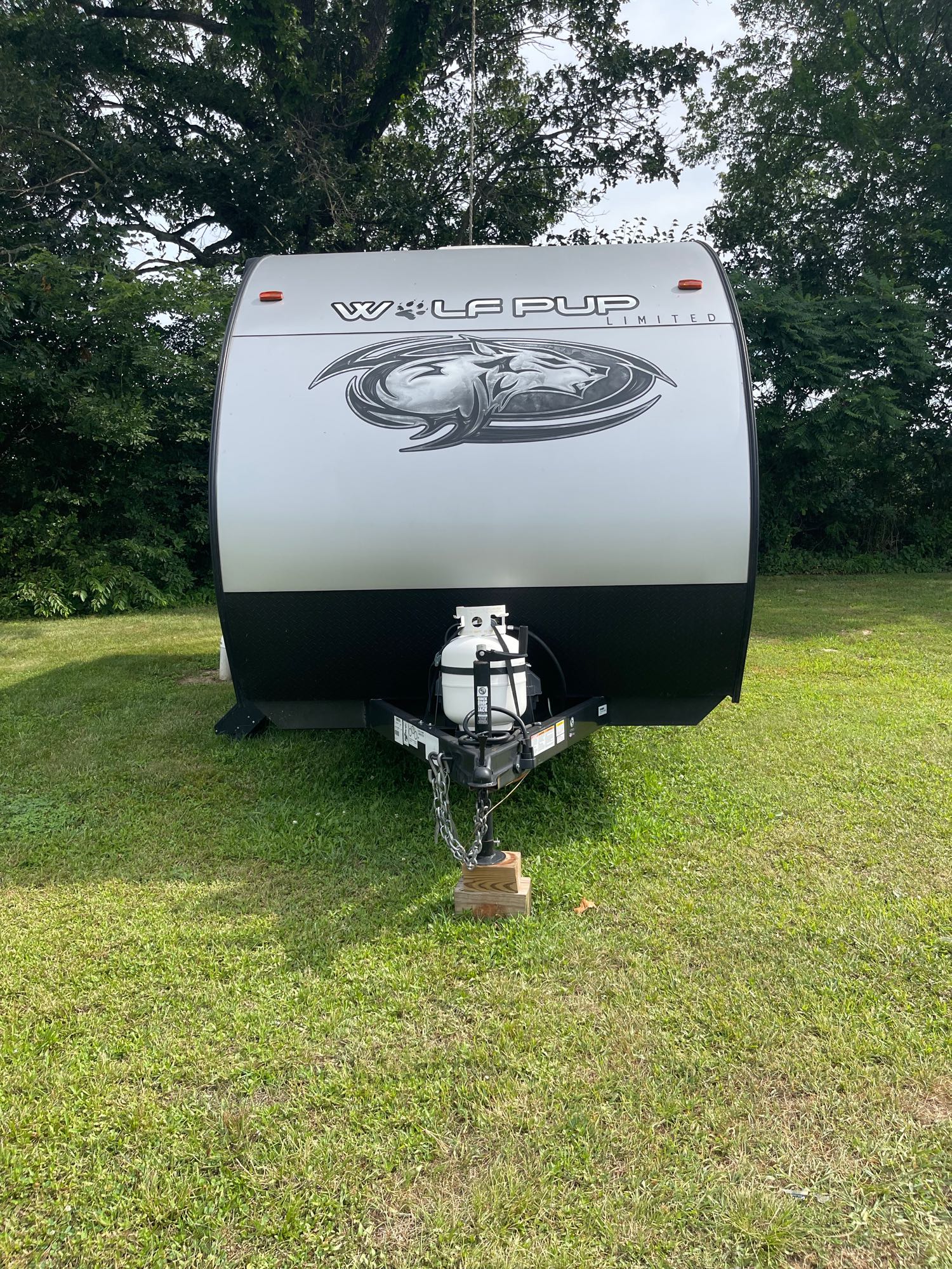 parked on grass under trees. Perfect for your RV rental adventure.|RV rental with door open