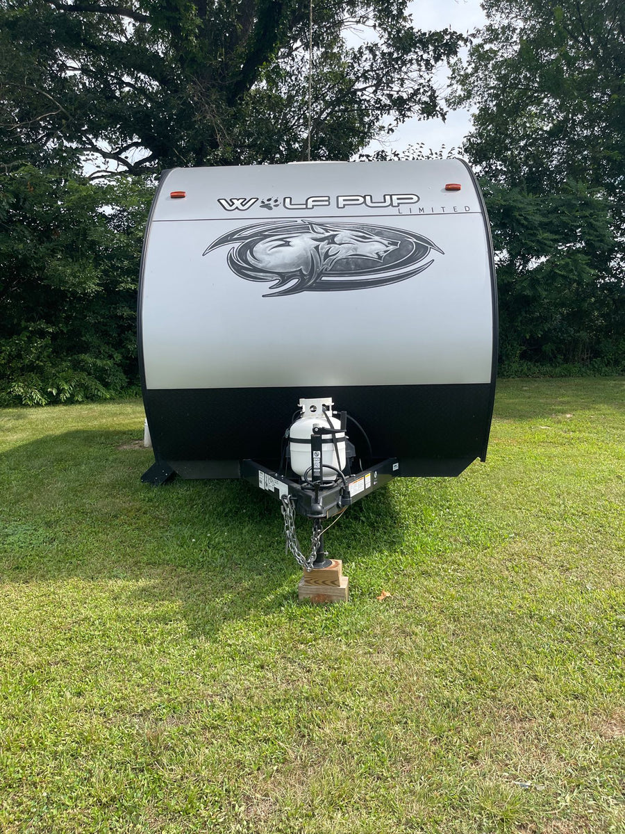 parked on grass under trees. Perfect for your RV rental adventure.|RV rental with door open