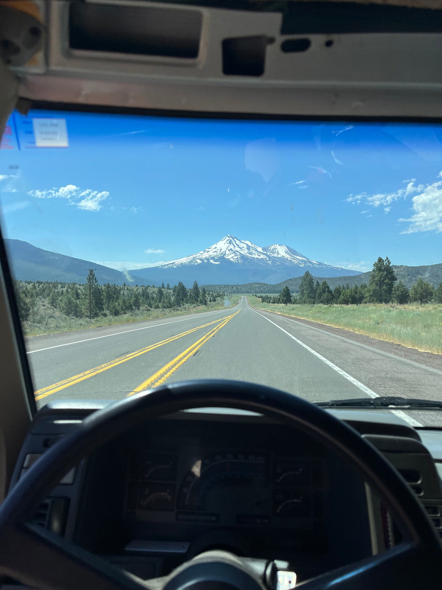 Scenic RV rental drive from a driver's view, heading toward snow-capped Mt. Shasta on a bright, clear day.