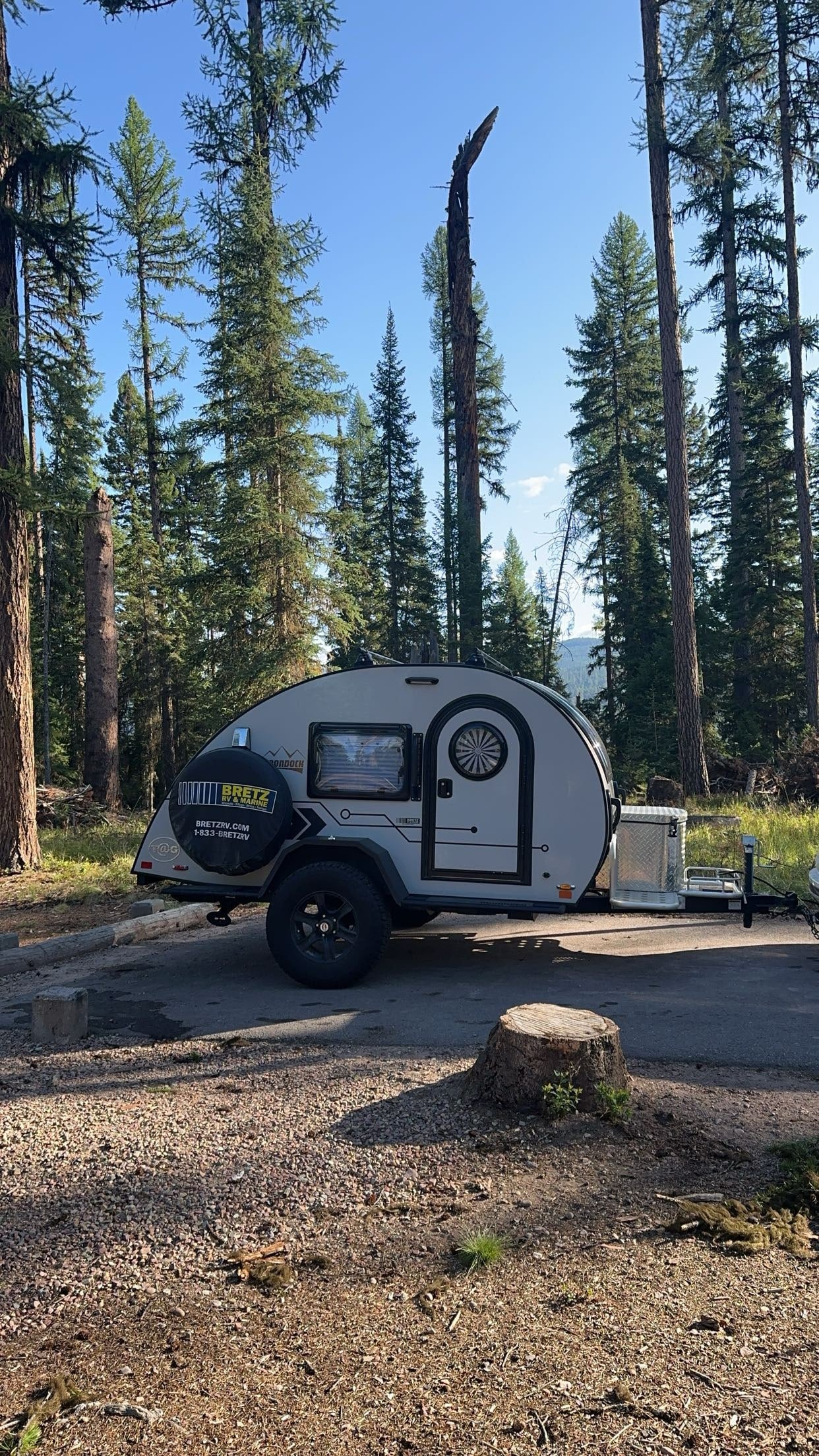 Modern teardrop rv rental parked in a peaceful forest campsite