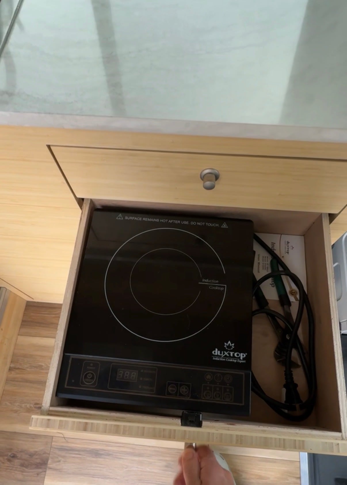 integrated toilet is revealed in light wood cabinetry