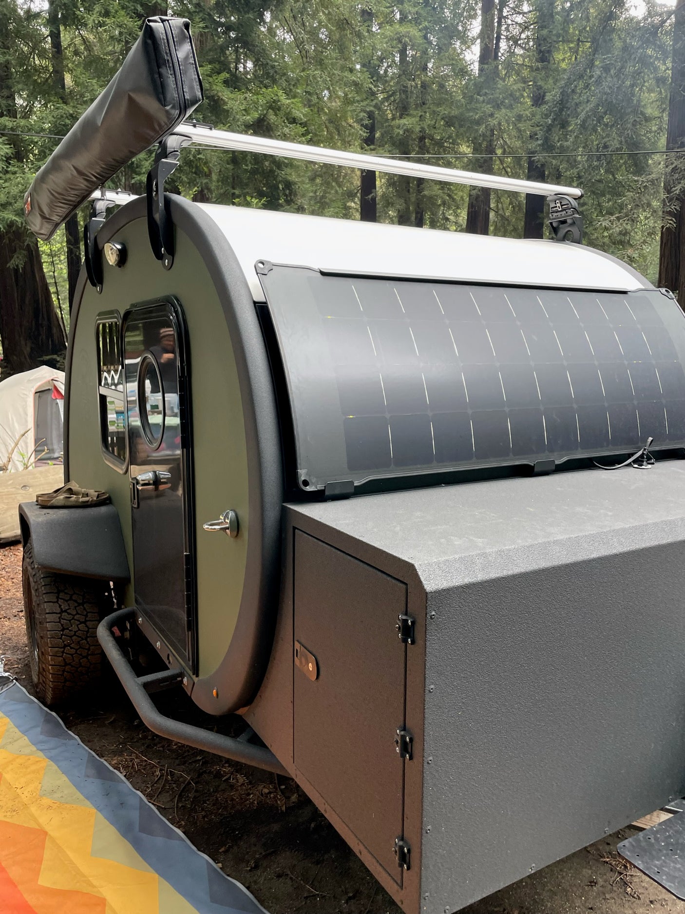 Adventure-ready teardrop trailer RV rental with solar panel & awning, perfect for camping in the redwoods.