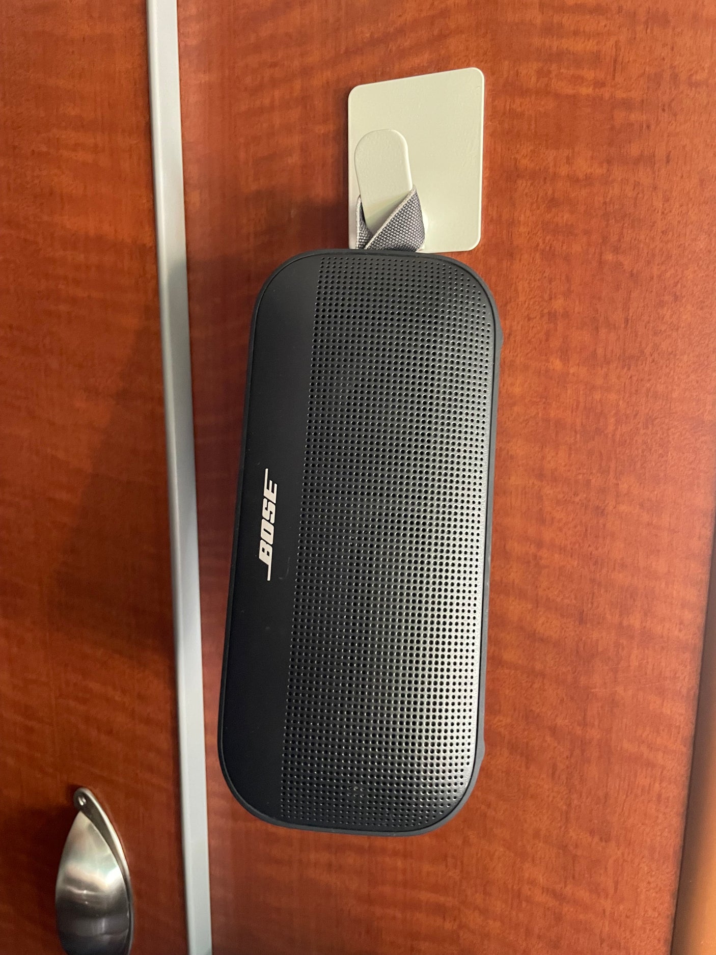 Stay entertained in your RV rental with this Bose portable speaker, conveniently hung on an adhesive hook on a wooden wall.