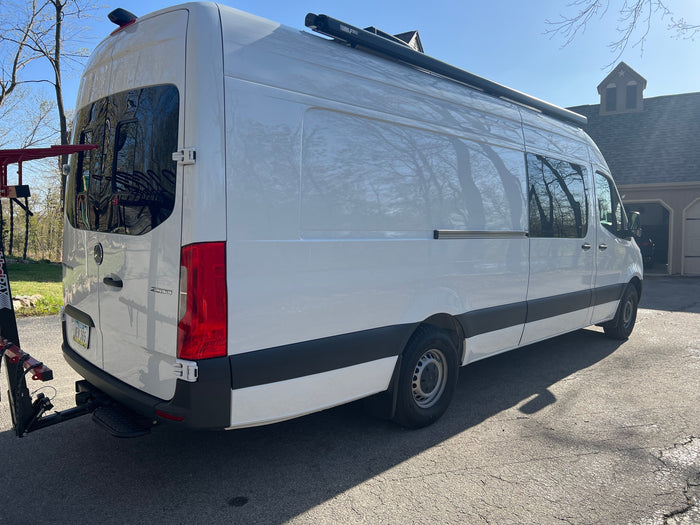 with Iowa plate NEN 365.|White Mercedes Sprinter camper van parked on asphalt