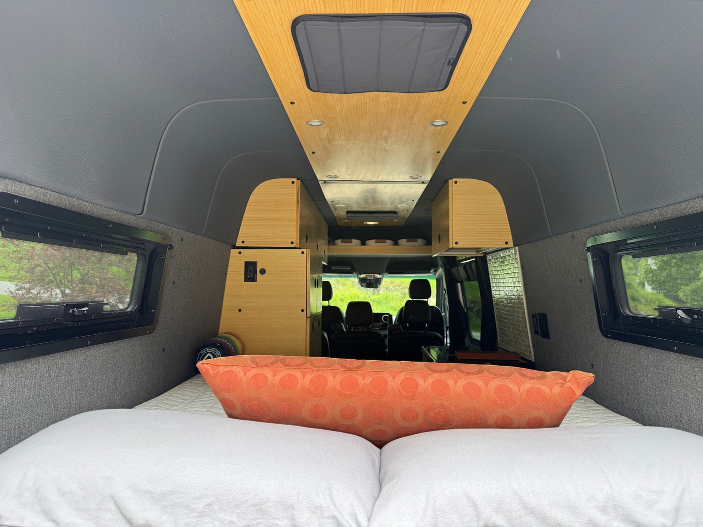 and sleek mosaic tile backsplash for comfortable travel.|Stylish RV rental interior featuring a compact bamboo kitchen with a dark sink
