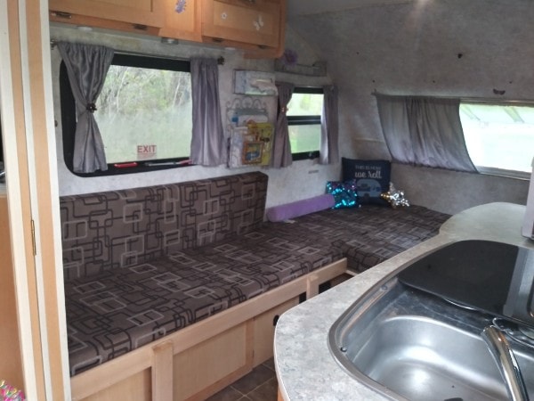 and fridge.|Inside your RV rental: a compact dinette with patterned seating