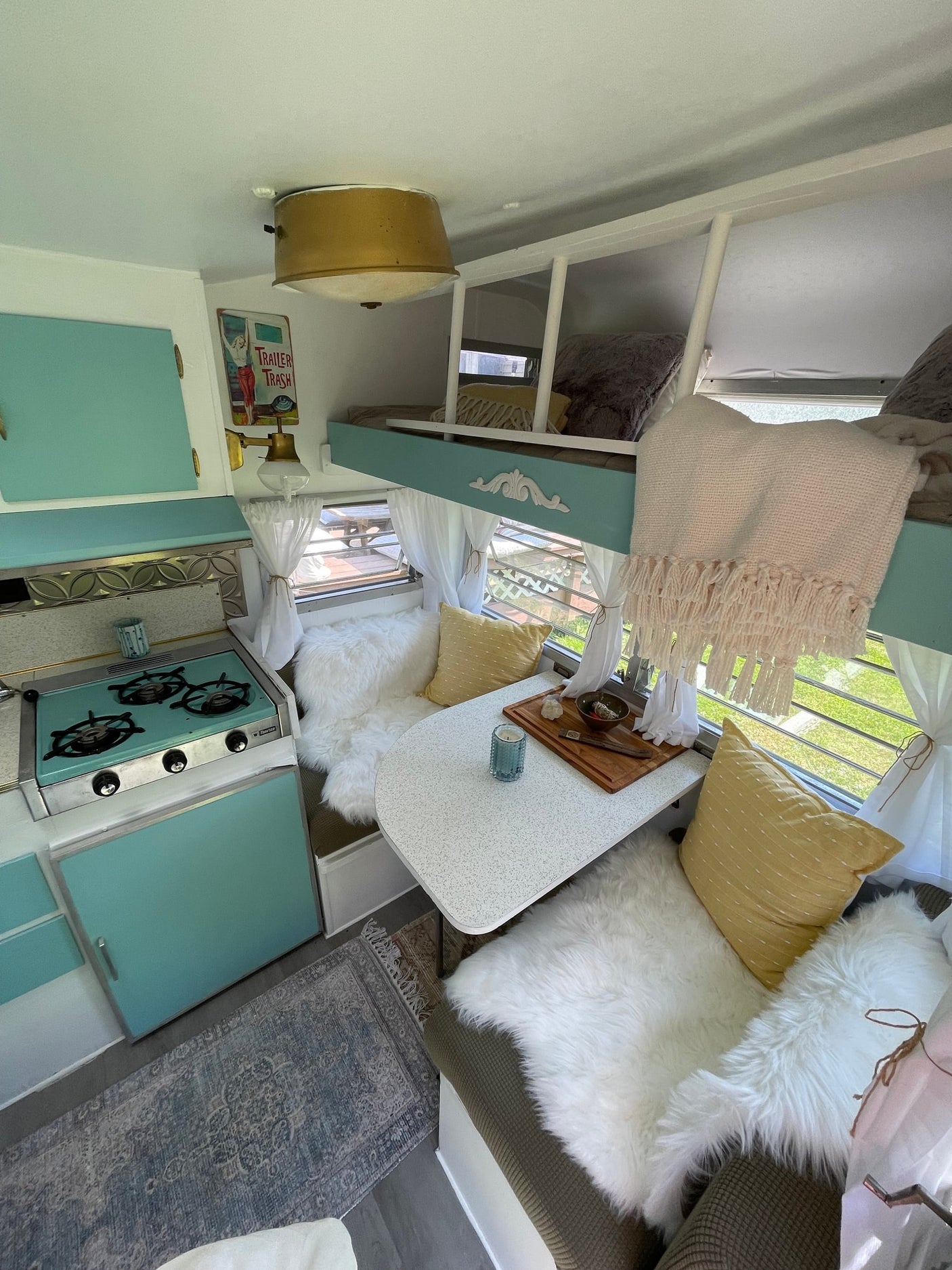 and cozy seating.|Inside this retro rv rental: a stylish light blue kitchenette