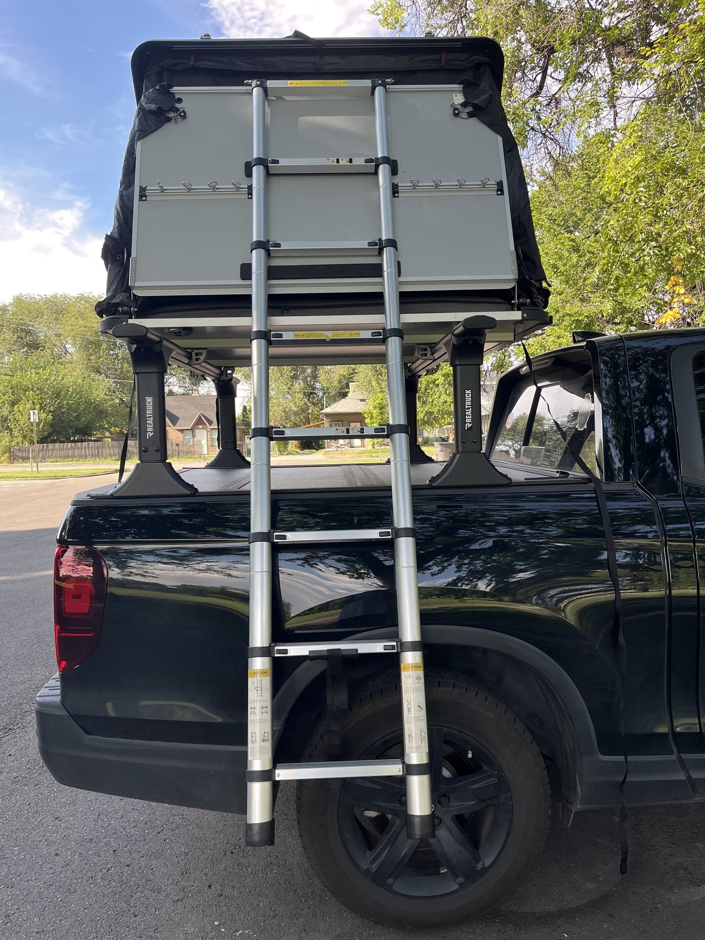 Closed hardshell viewed from above the truck bed with the telescoping ladder stowed across the crossbars — photo 5