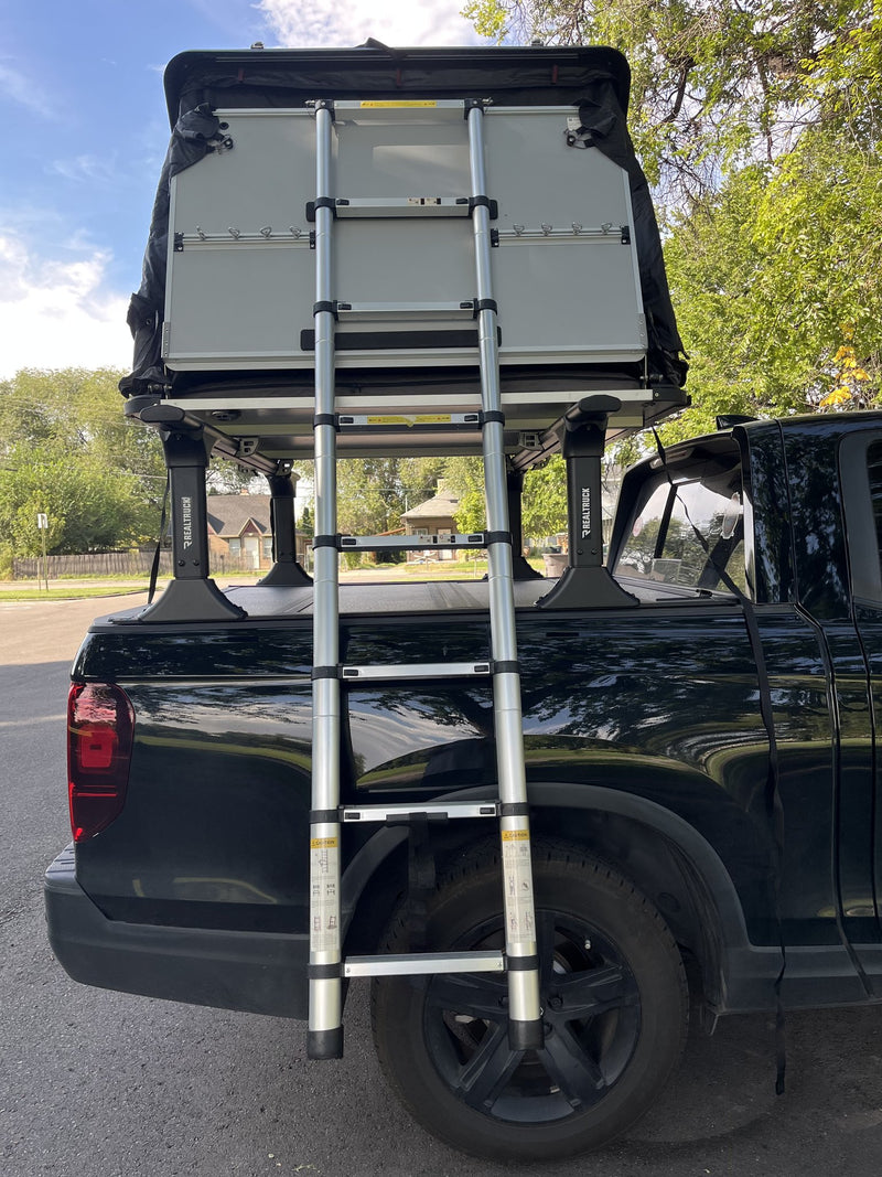 Closed hardshell viewed from above the truck bed with the telescoping ladder stowed across the crossbars — photo 5