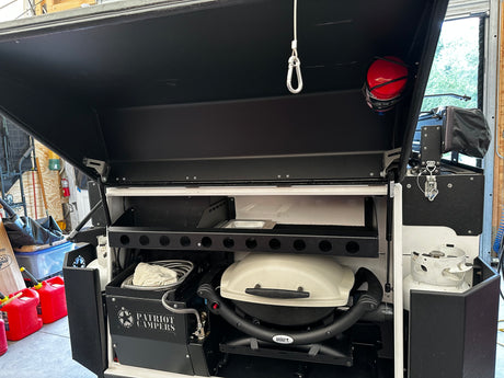 Rear compartment with swing-out Weber Q1000 BBQ and two propane tanks