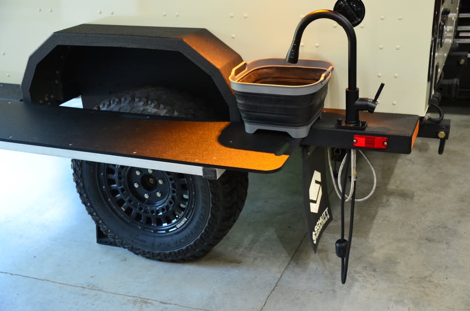 2014 Schutt Industries XVenture XV-2 overland trailer — upgraded alloy wheel with Cooper S/T Maxx tire beside the galley prep table — photo 14