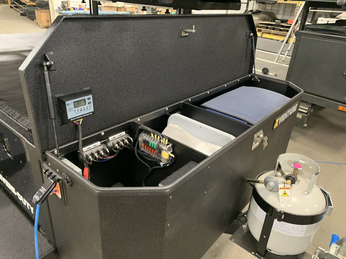 Front storage box open showing the solar charge controller, fused distribution panel and propane bottle — photo 22