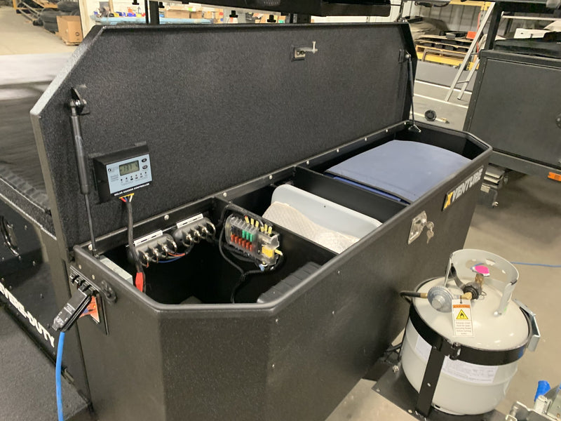 Front storage box open showing the solar charge controller, fused distribution panel and propane bottle — photo 22