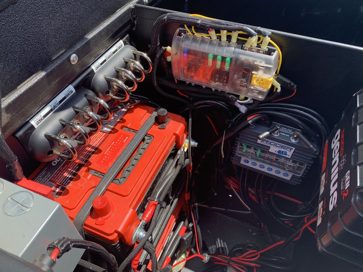 Battery compartment with the house battery, fuse block, wiring harness and NOCO Genius charger — photo 25