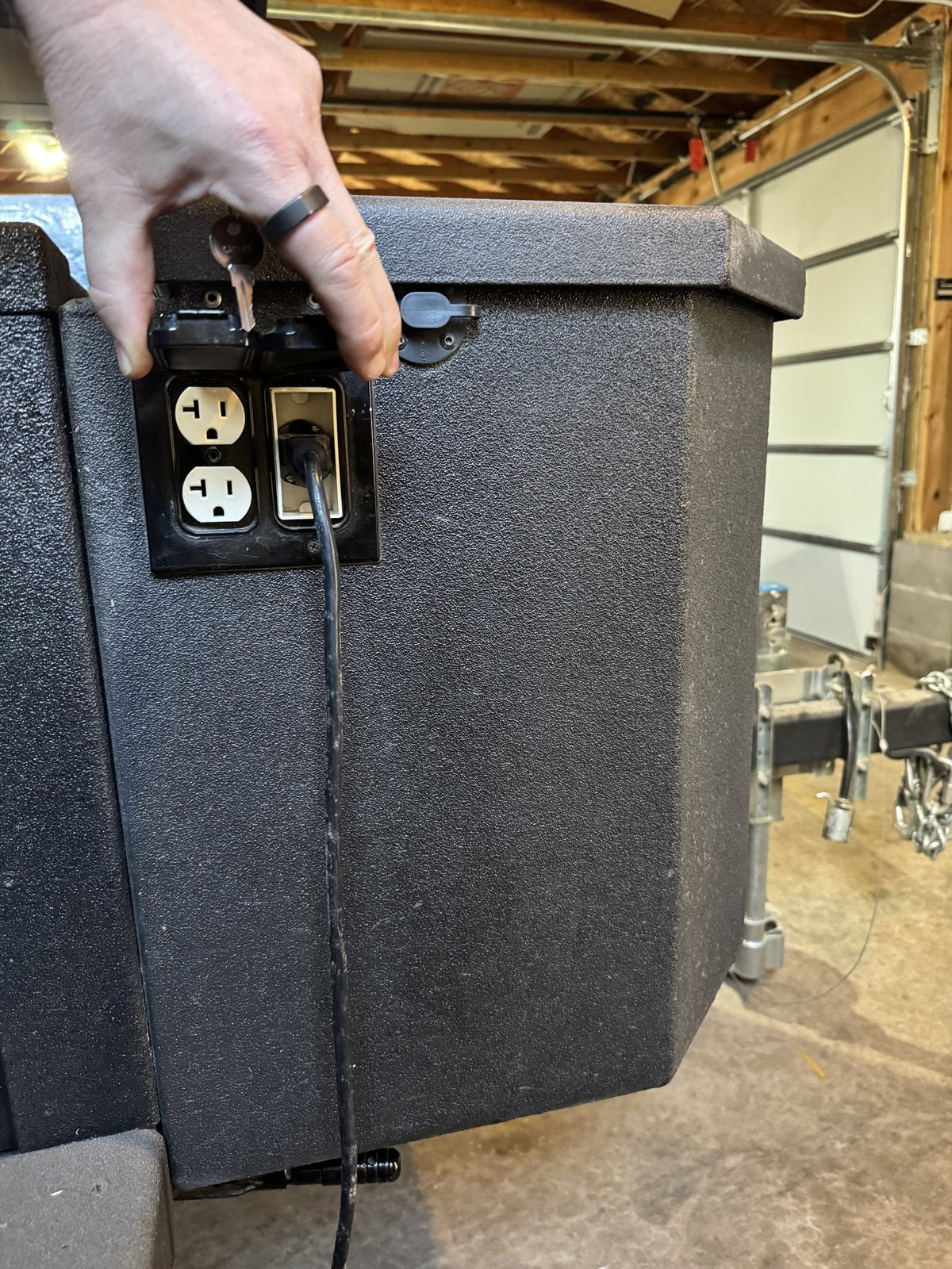 Exterior shore-power inlet and weatherproof outlet panel on the side of the trailer — photo 23