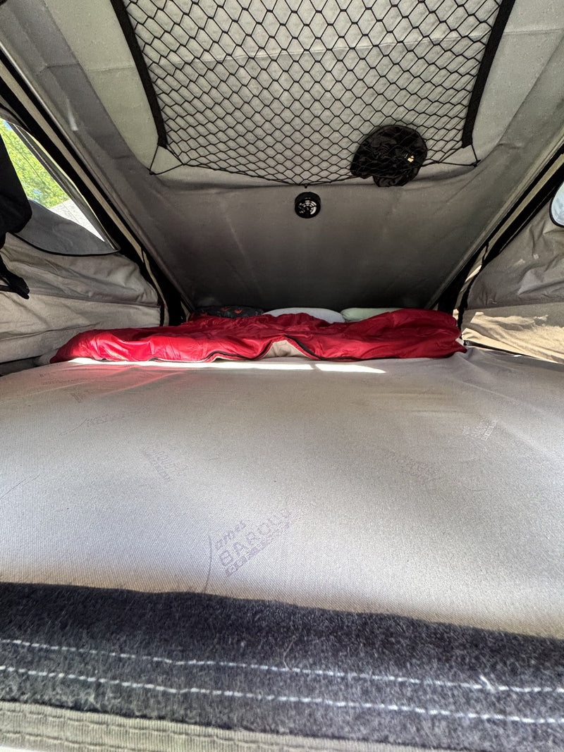 Interior of the tent showing the mattress, overhead storage net and ceiling-mounted exhaust fan — photo 8
