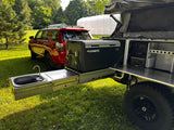 Outdoor kitchen and sink area with tow vehicle in background