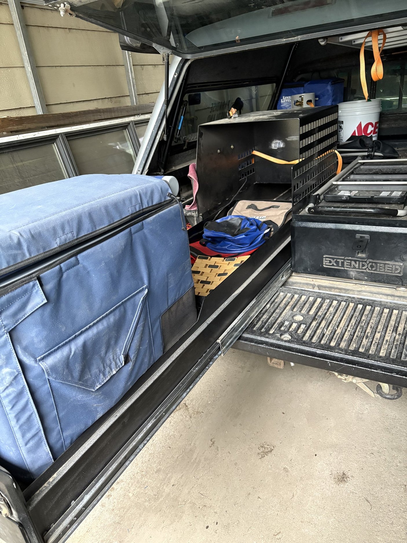 Padded cover laid over the Extendobed deck alongside a camp stove and gear inside the truck bed canopy
