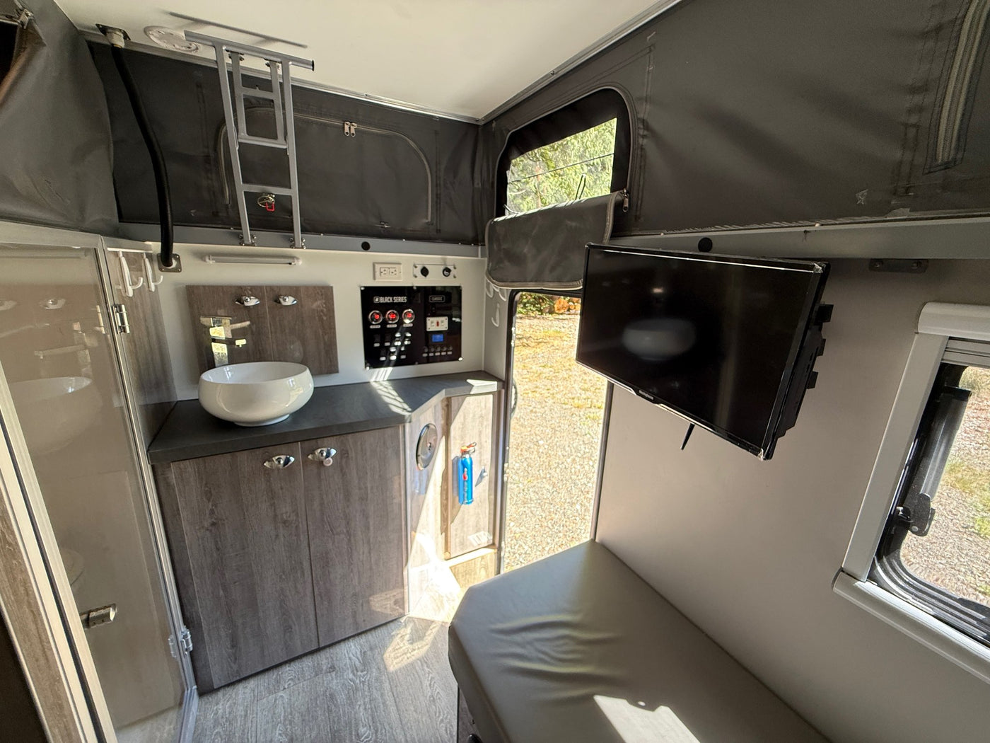 Interior wide view showing the vessel sink and vanity, Black Series control panel, mounted TV and seating — photo 10