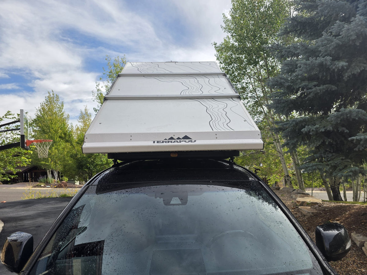 Head-on view of the closed Terrapod RTTx XL hardshell from the front of the vehicle, showing the topo-line graphic on the lid, the TERRAPOD logo and the slim aerodynamic closed profile — photo 6