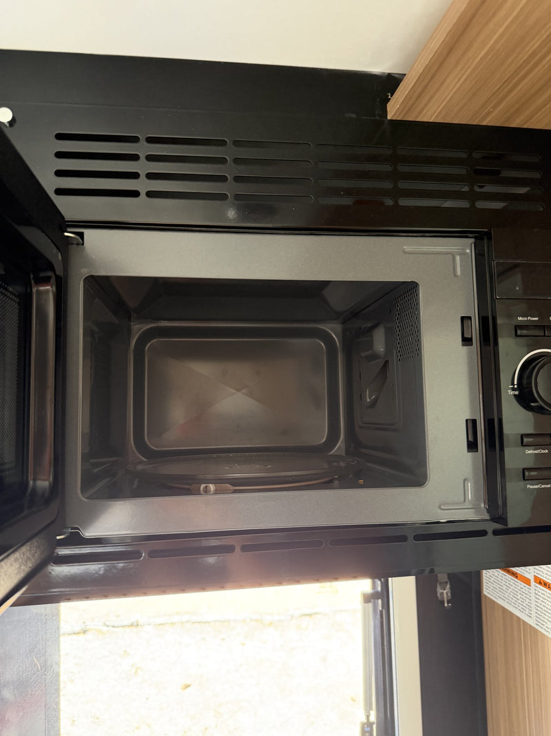 Overhead microwave with the door open showing the clean interior cavity, turntable and control panel — photo 13
