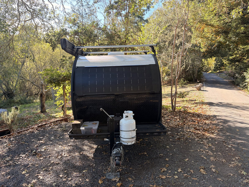 Bean teardrop camper rear three-quarter with trailer tongue, propane tank and spare tire — photo 4