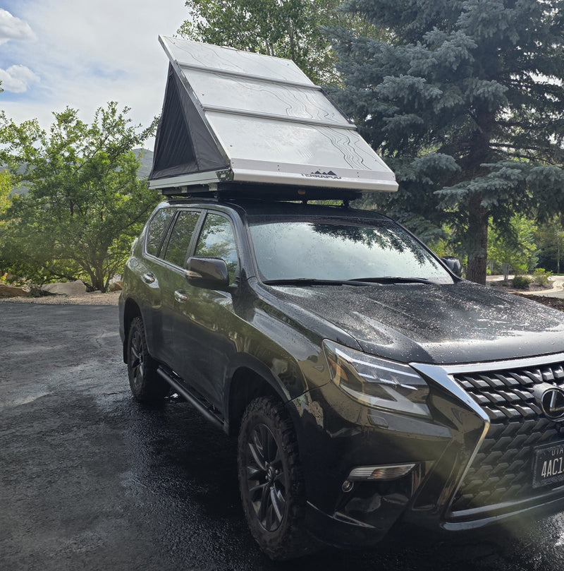 Front three-quarter view of the Terrapod RTTx XL rooftop tent opened on the vehicle roof rack, showing the aluminium shell edge, the TERRAPOD badge on the side rail and the wedge-shaped tent profile — photo 2