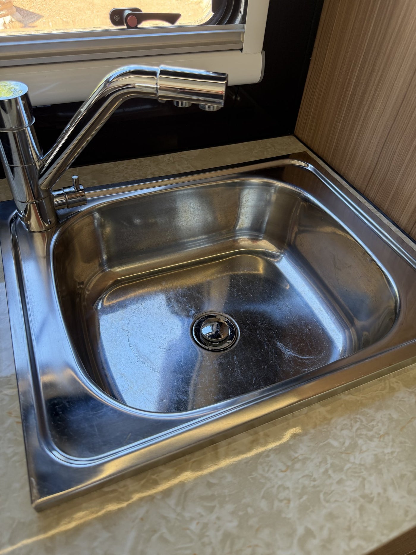 Close view of the stainless steel galley sink and chrome pull-out mixer tap, clean and free of damage — photo 12