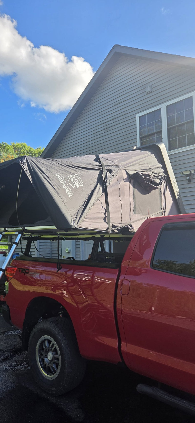 iKamper Skycamp 3.0 Rocky Black opened on a red Toyota Tundra bed rack, clamshell raised against blue sky — photo 1