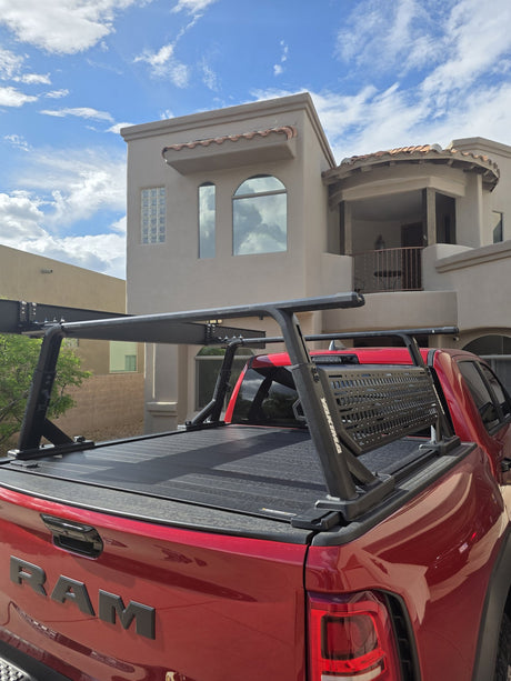 Retrax Pro XR retractable tonneau cover and Yakima OverHaul HD bed rack mounted on a red RAM 1500, wide view showing the full rack with MOLLE panel