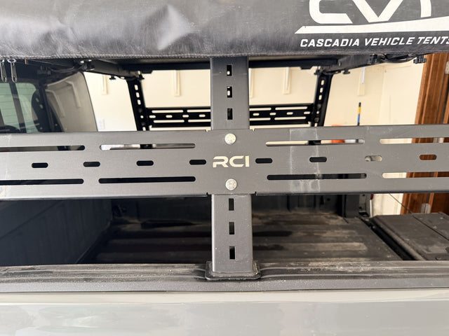 RCI-branded slotted load bar and adjustable vertical upright of the HD bed rack, shown installed in the truck bed