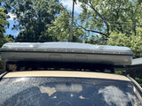 Front view of the closed James Baroud hardshell tent above the vehicle windshield, showing the full width of the XXL shell