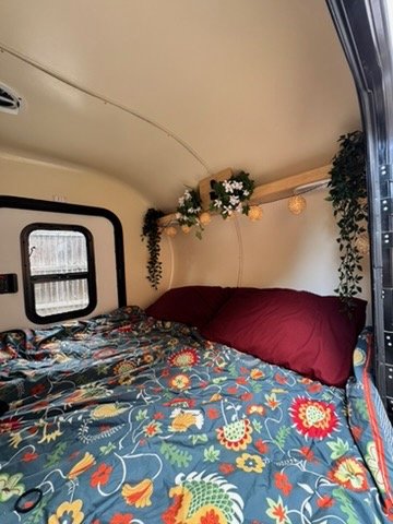 Cabin interior toward the rear with bedding and overhead cabinet