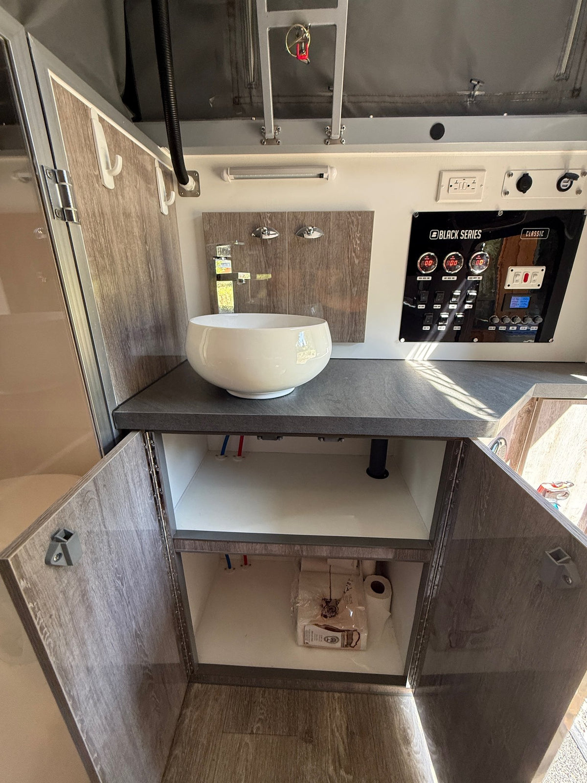 Vanity with the cabinet doors open showing under-sink storage, alongside the Black Series Classic control panel — photo 18