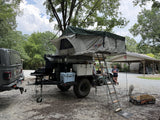The Pope rooftop tent and awning set up at a campsite