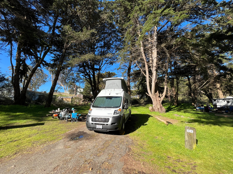 Enjoying the outdoors in an RV rental: A Winnebago campervan with its pop-top extended at a sunny, wooded campsite. — photo 6