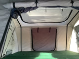 RV rental rooftop tent interior: Bright sleeping area with green mattress & overhead mesh storage. Ideal for camping.