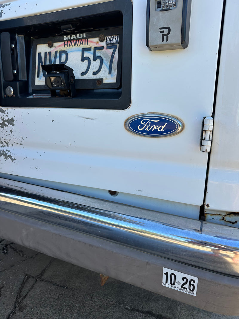 Hawaii rv rental Ford van's rear. Shows NVR 557 license (exp. Mar 2026), backup camera, and key lockbox. — photo 16